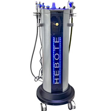 Air Essence™ Hydra Facial Therapy ESSENTIAL to wysokie, srebrno-czarne urządzenie kosmetyczne na kółkach z niebieskim oświetleniem LED, oznaczone jako 