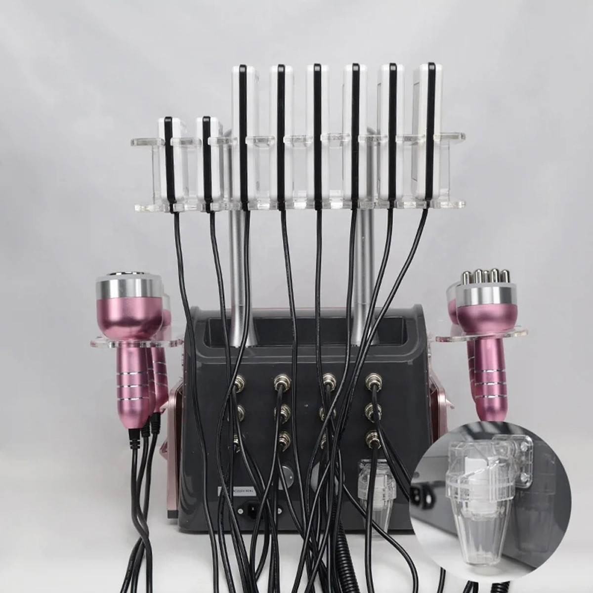 Widok na tył urządzenia windScrub 40K Kawitacyjne urządzenie wyszczuplające 6 w 1, Rose1 wyposażone w wiele końcówek i sond, wszystkie podłączone do czarnej jednostki bazowej.